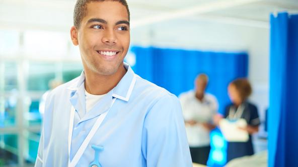 A nurse on a ward, smiling. 
