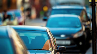 A row of cars on a busy road. 