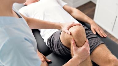 A physiotherapist checking a patient's knee.