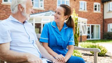 A nurse and a patient on a bench.