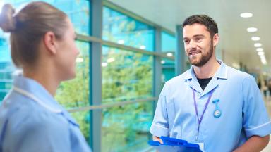 Student nurses talking in a corridor.