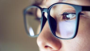 A close up of a screen reflected in a person's glasses.