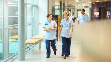 A diverse group of nurses walking down a corridor.