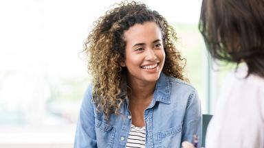 Two colleagues meeting, one smiling.
