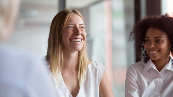 An office worker smiling in a meeting.