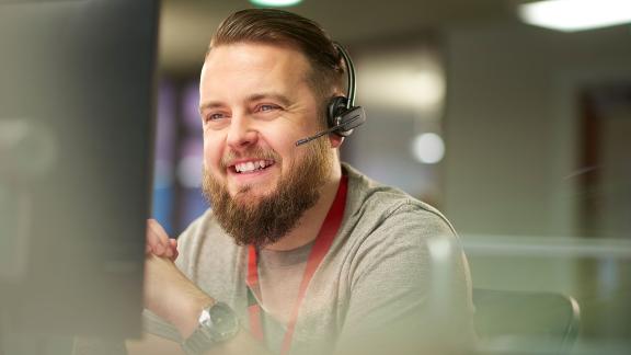 A smiling office worker wearing a headset.