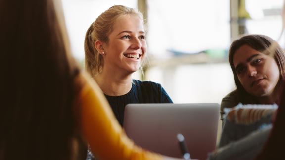 A young person smiling during a meeting.