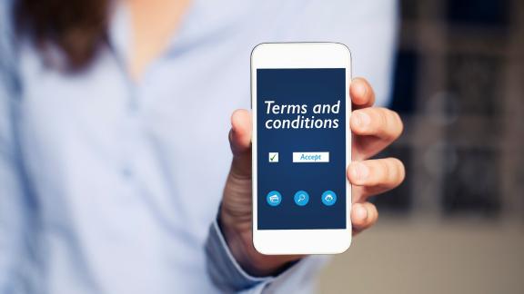 Image of lady holding a phone with terms and conditions on the screen