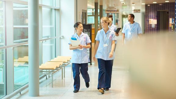 A diverse group of nurses walking down a corridor.