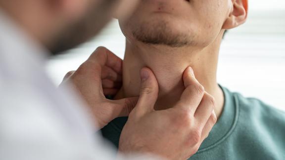 A doctor checking a patient's throat.