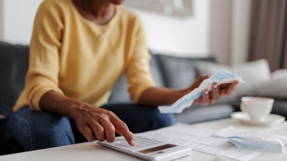 A person using a calculator and receipts to budget.