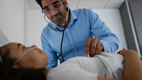 A doctor checking a patient's heart with a stethoscope.