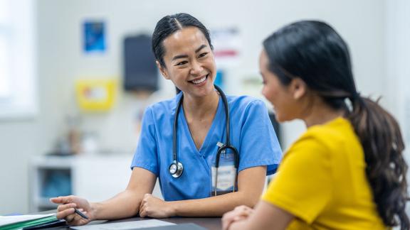 Doctors talking at a nurses station in a hospital