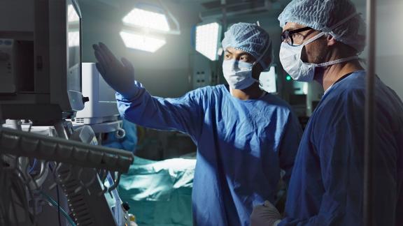 Two surgeons having a discussion pointing to a screen 