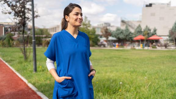 A person in medical uniform outside having a break
