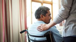 A carer comforting a wheelchair user.