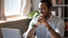 A home worker, on a video call, smiling.