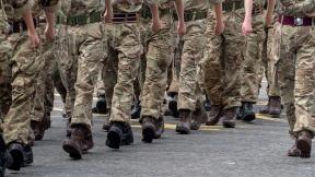 A close up of the legs of marching soldiers.