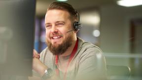 A smiling office worker wearing a headset.