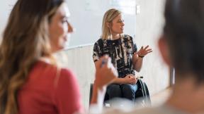 A wheelchair user leading a meeting.