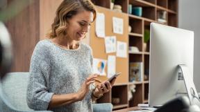 Photo of a business woman using smartphone while working