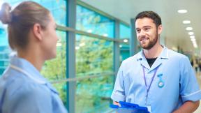 Student nurses talking in a corridor.