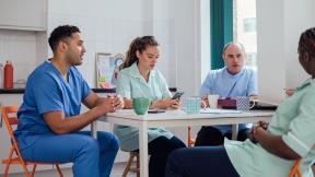 NHS staff talking in a staff room.