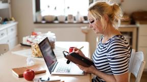 A  person working from home at their kitchen table.