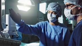 Surgeons discussing while looking at a screen