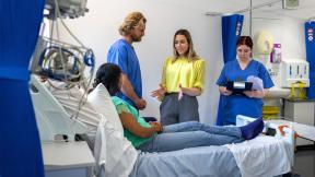 Female doctor consulting patient with students