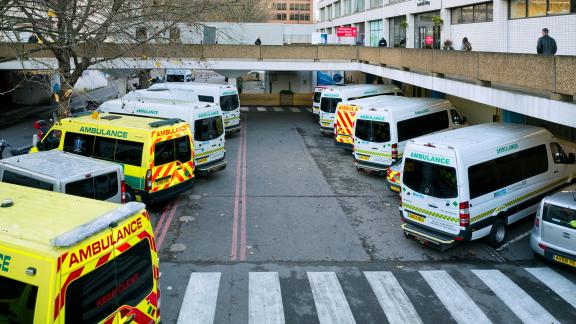 Ambulances parked in bays outside of a hospital.