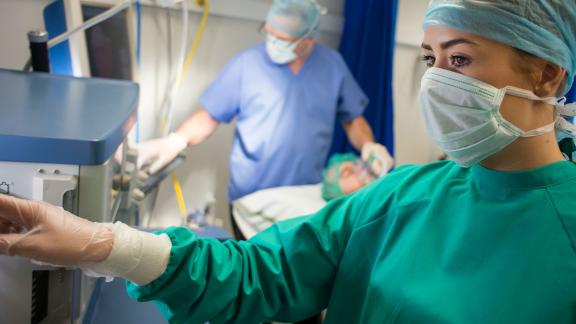 An anaesthetist checking a monitor.