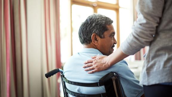 A carer comforting a wheelchair user.