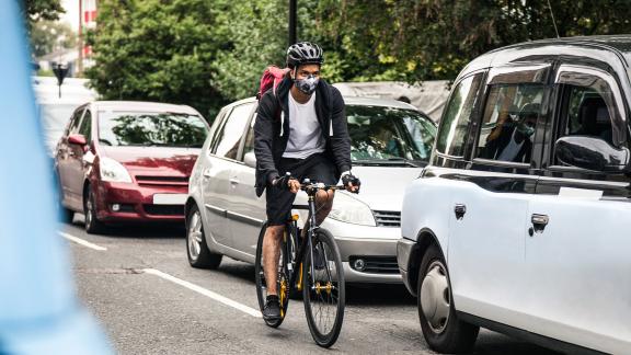 A cyclist commuting through traffic.
