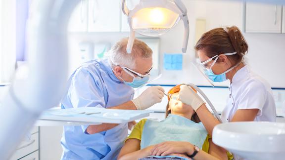 A dental appointment with a dentist, patient and dental nurse.