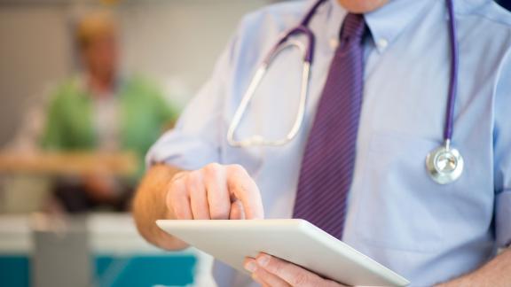 A doctor checking a tablet.