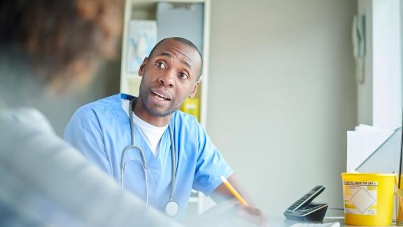 A doctor mid-consultation with a patient.
