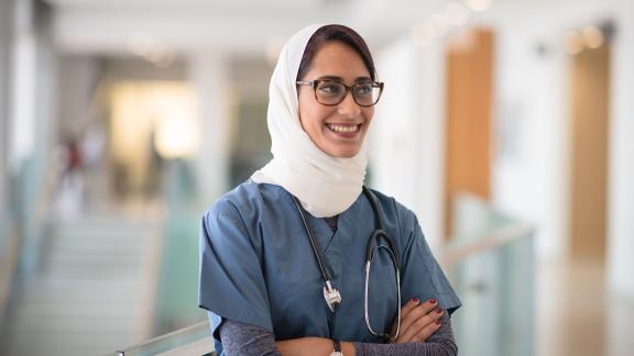 A doctor, folding their arms and smiling.