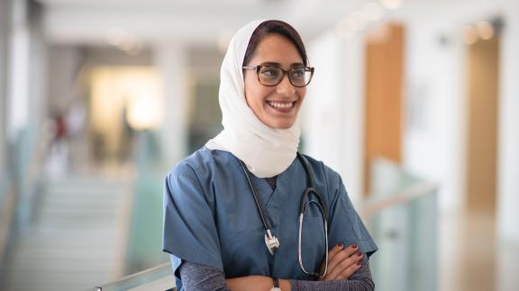 A doctor, folding their arms and smiling. 