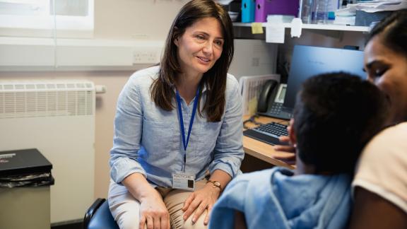 A GP in a consultation with a mother and child.