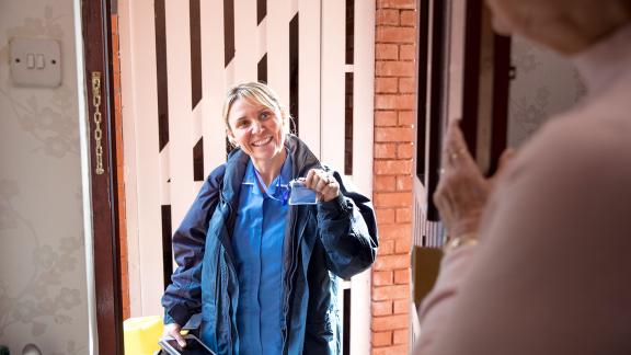 A healthcare home visitor, smiling.