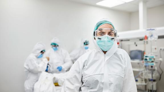 A healthcare worker in full PPE, on a ward.