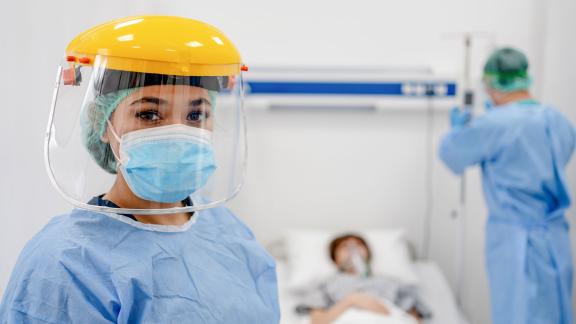A healthcare worker in full PPE on a ward.