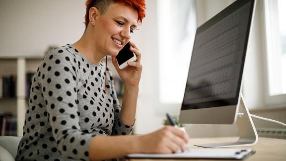 A home worker, taking notes during a phone call.