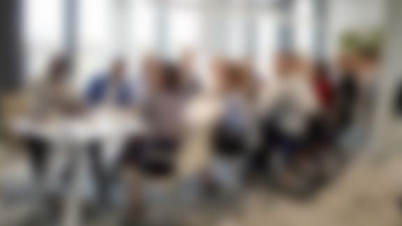 A blurred photograph of a meeting.