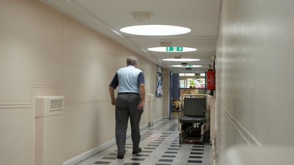 A man walking down a hospital corridor. 