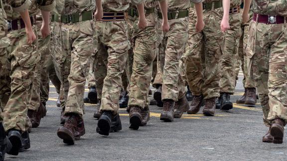 A close up of the legs of marching soldiers.