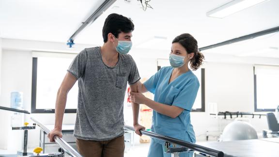 A patient and physiotherapist wearing masks during a session.