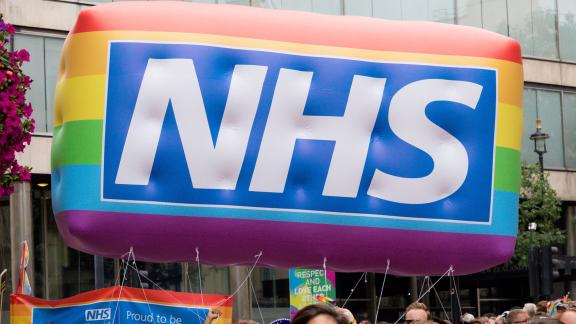 A huge NHS rainbow logo balloon at a pride march.