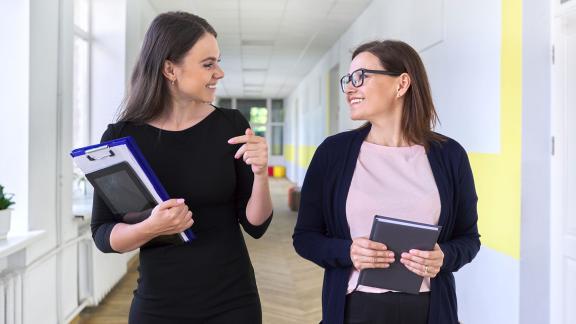 Two colleagues walking down a corridor. 